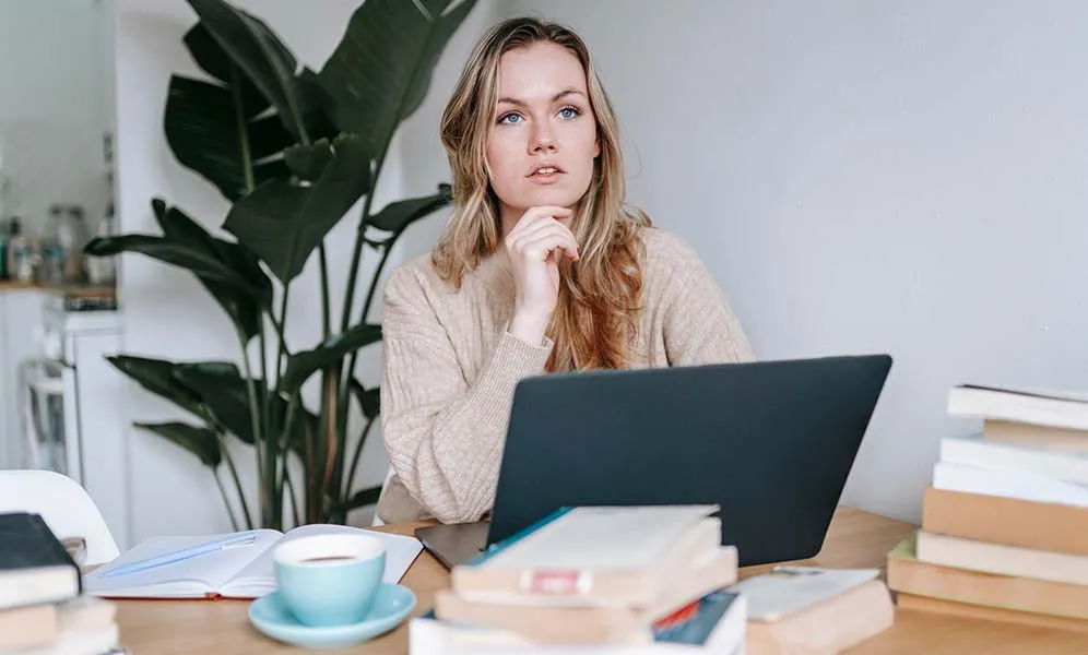 Desk with folded textiles and small brass lamp